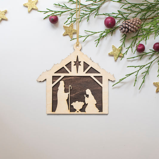 a wooden ornament with a nativity scene on it